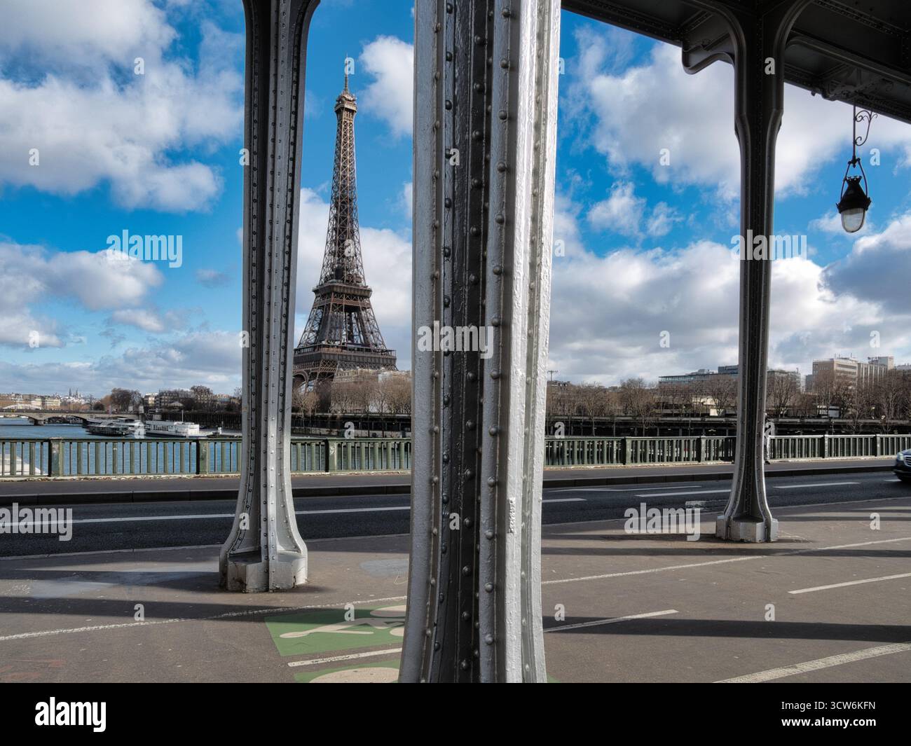Vista della Torre Eiffel dal ponte Bir-Hakeim - la Torre Eiffel è stata caratterizzata in modo prominente su un cielo blu luminoso con nuvole bianche, incorniciata dal metallo grigio Foto Stock