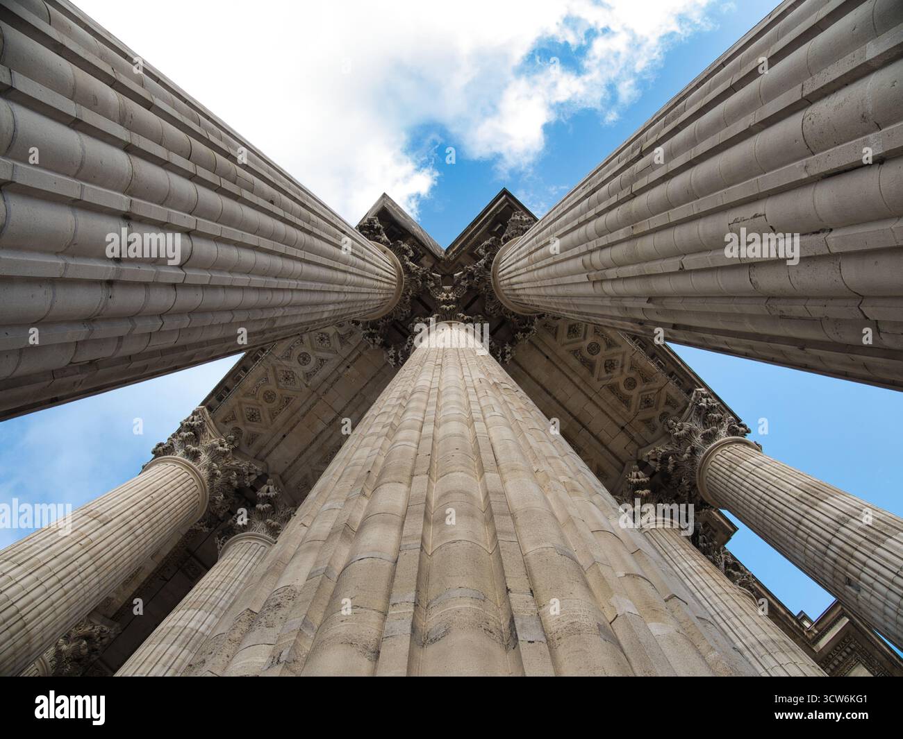 Colonne neoclassiche da Low Angle Perspective - spettacolare vista a basso angolo che guarda dritto tra le monumentali colonne di pietra scanalata verso una riccità Foto Stock