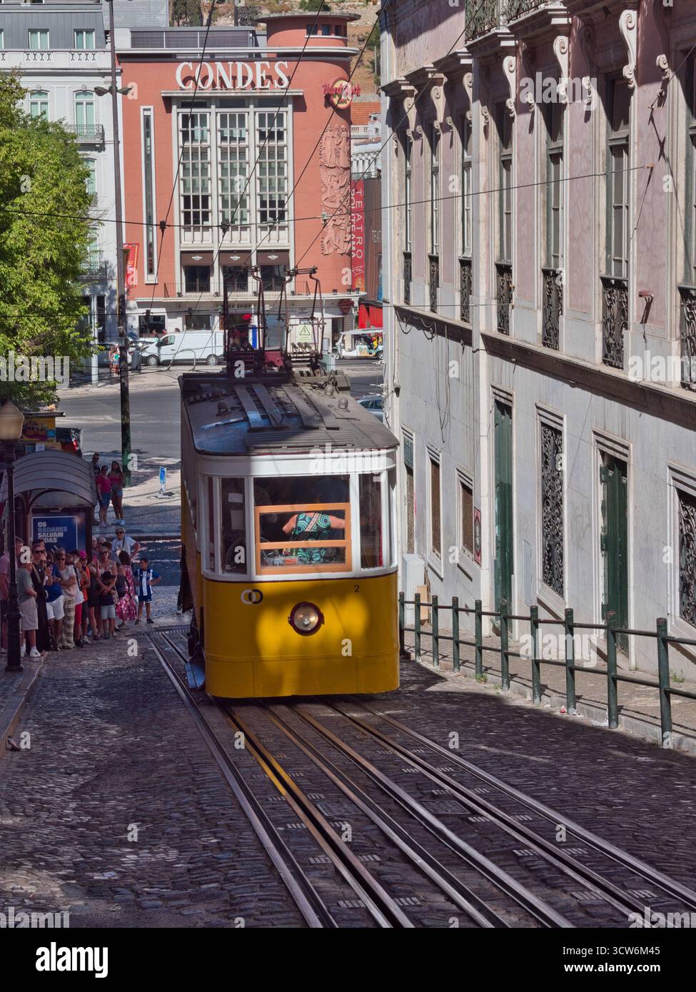 Funicolare di Glória sulla ripida collina di Lisbona - tram d'epoca giallo Elevador da Glória che sale sulla ripida collina di Bairro alto di Lisbona su una strada acciottolata, accanto Foto Stock