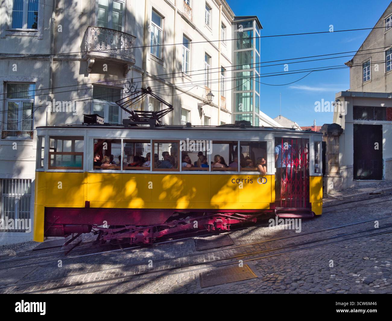 Funicolare di Glória sulla ripida collina di Lisbona - tram d'epoca giallo Elevador da Glória che sale sulla ripida collina di Bairro alto di Lisbona su una strada acciottolata, accanto Foto Stock