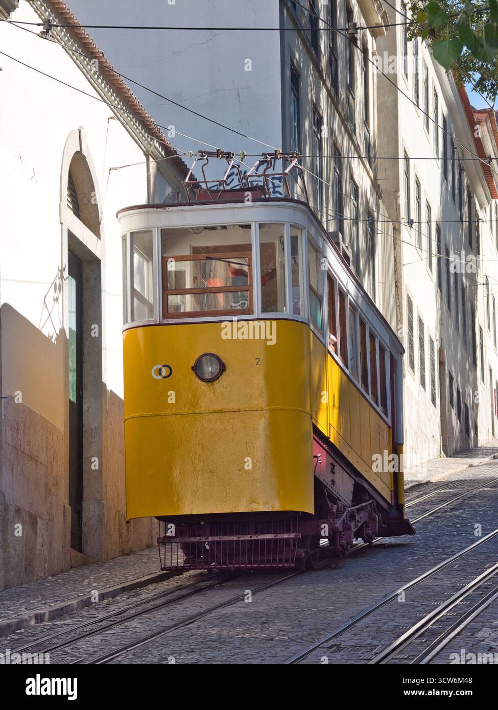 Funicolare di Glória sulla ripida collina di Lisbona - tram d'epoca giallo Elevador da Glória che sale sulla ripida collina di Bairro alto di Lisbona su una strada acciottolata, accanto Foto Stock