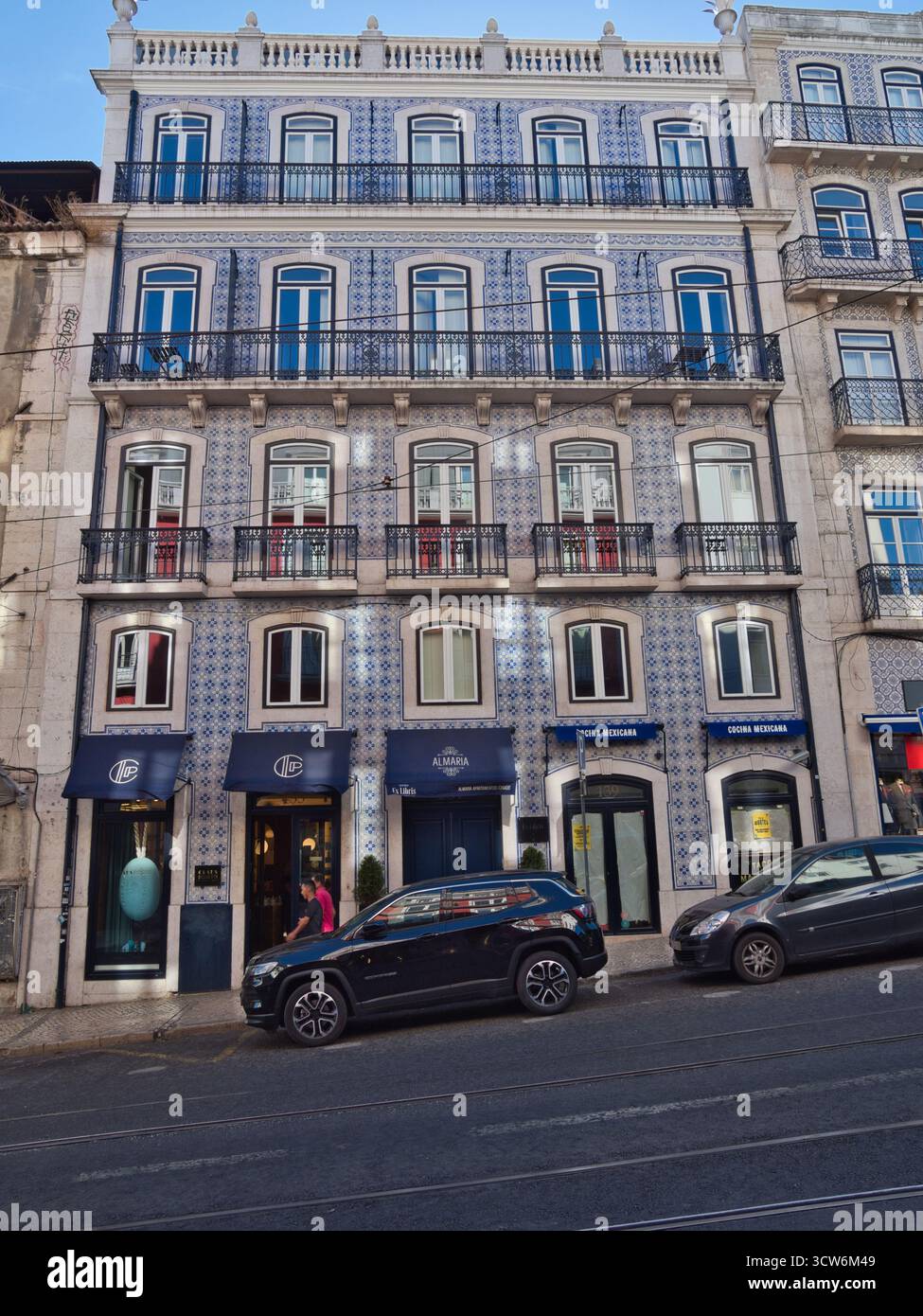 Facciata in mattonelle di Azulejo con balconi a Lisbona - tradizionali piastrelle portoghesi di Azulejo coprono una facciata storica a cinque piani con balconi e gro Foto Stock