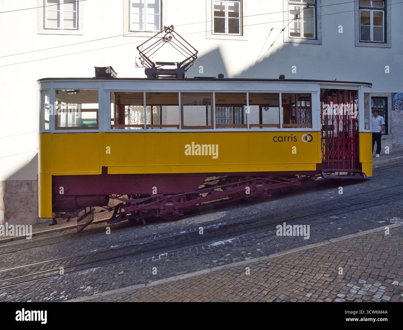 Funicolare di Glória sulla ripida collina di Lisbona - tram d'epoca giallo Elevador da Glória che sale sulla ripida collina di Bairro alto di Lisbona su una strada acciottolata, accanto Foto Stock