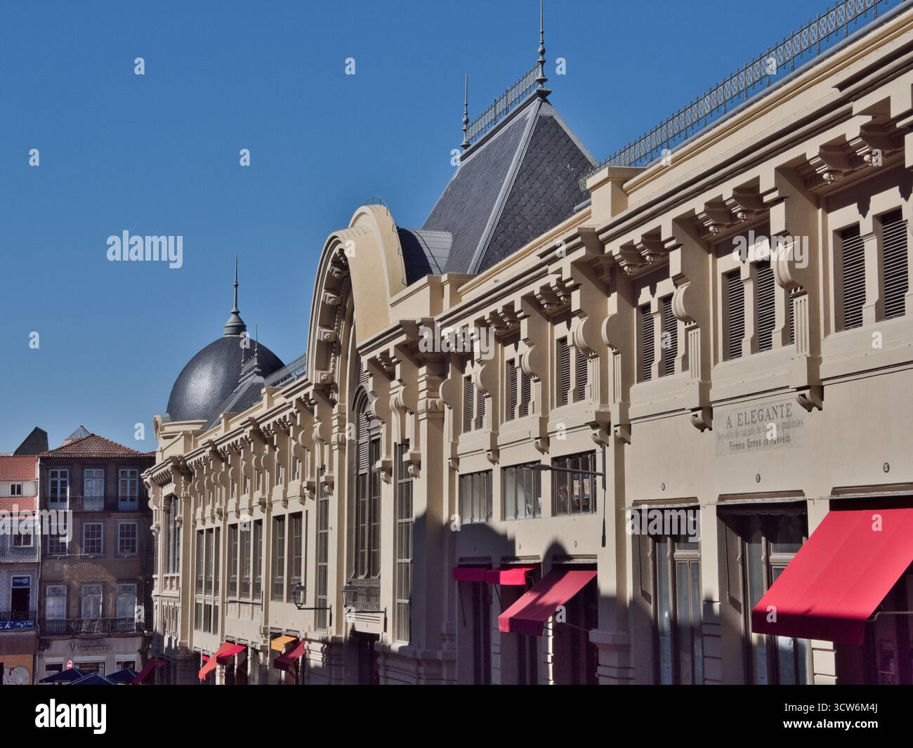Maestoso edificio neoclassico esterno a Porto, Portogallo - Vista ad angolo basso di un grandioso edificio commerciale storico con un tetto mansardato e cupole un Foto Stock