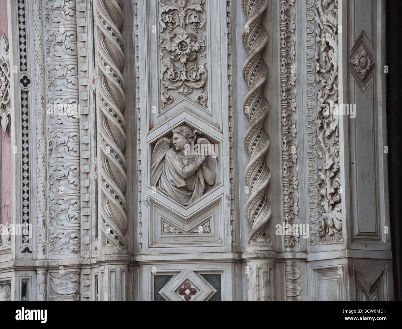 Rilievo dell'Angelo in marmo e colonne a spirale sulla facciata del Duomo - primo piano di intricati dettagli intagliati in marmo con un rilievo d'angelo in preghiera fiancheggiato da heavi Foto Stock