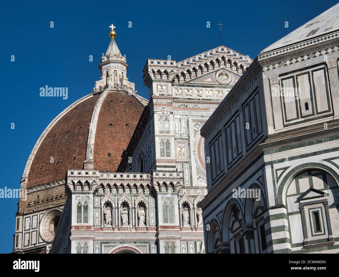 Vista del Duomo di Firenze, del Duomo e del complesso del Battistero - primo piano dall'angolo basso che mostra la cupola in terracotta, la facciata in marmo ornato del Duomo di Firenze, Foto Stock