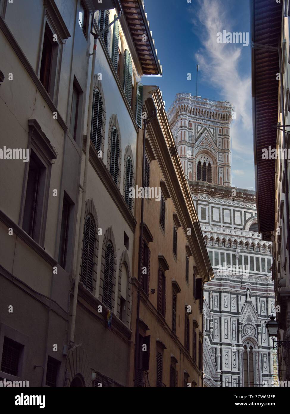 La facciata del Duomo e la Torre di Giotto incorniciate in una stretta via - Una vista unica della facciata in marmo ornato e della cima del Campanile di Giotto, ben incorniciata tra di loro Foto Stock