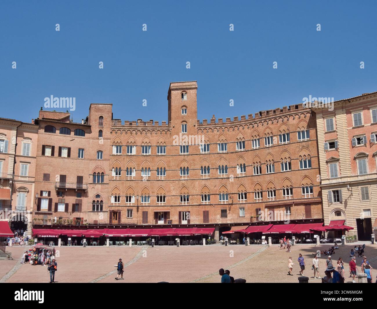 Piazza del campo e Palazzo pubblico a Siena - ampia vista orizzontale della facciata curva, medievale, in mattoni rossi del Palazzo pubblico e della trafficata piazza Foto Stock