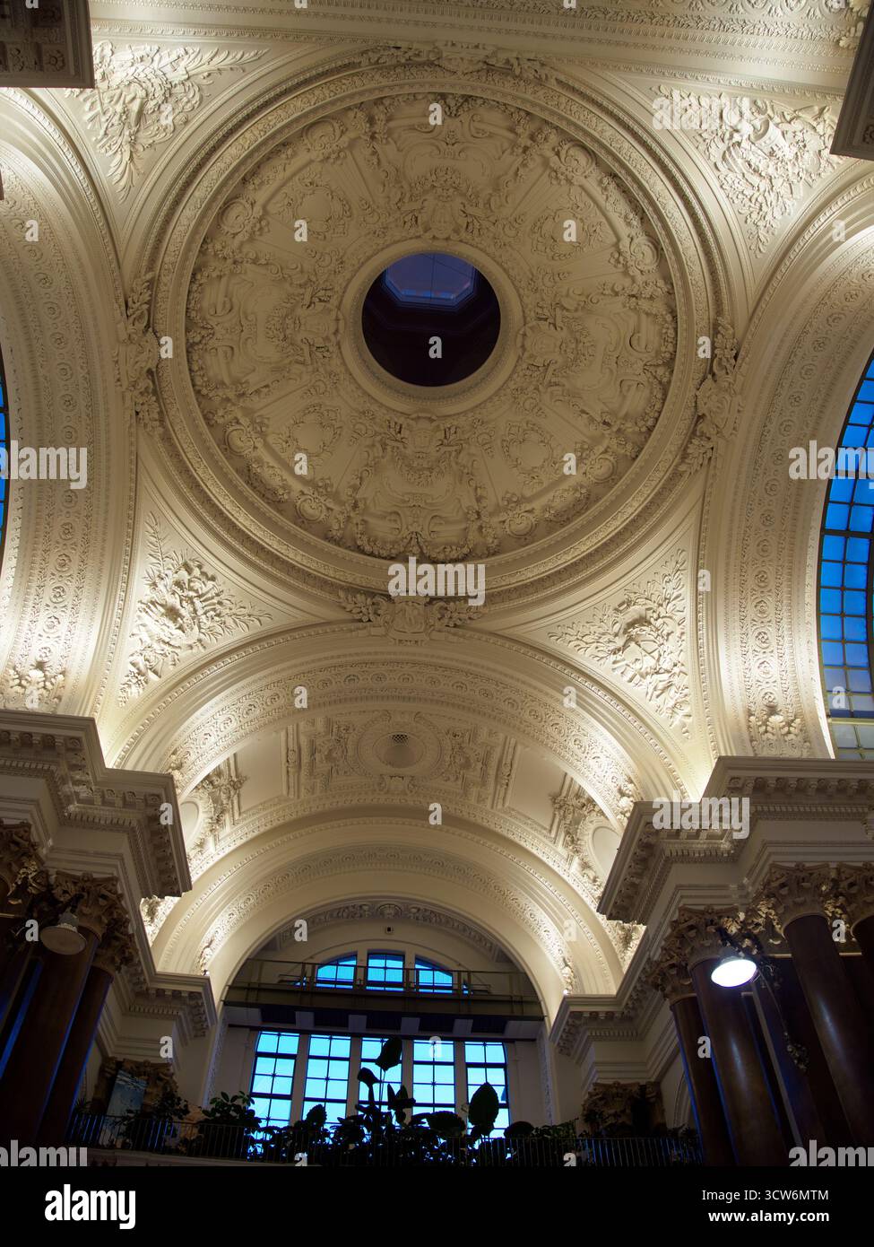 Grand Hall Dome Interior, Brussels Exchange - Vista ad angolo basso della cupola, del soffitto ornato e delle colonne all'interno dello storico edificio Bourse (Exchange) i Foto Stock