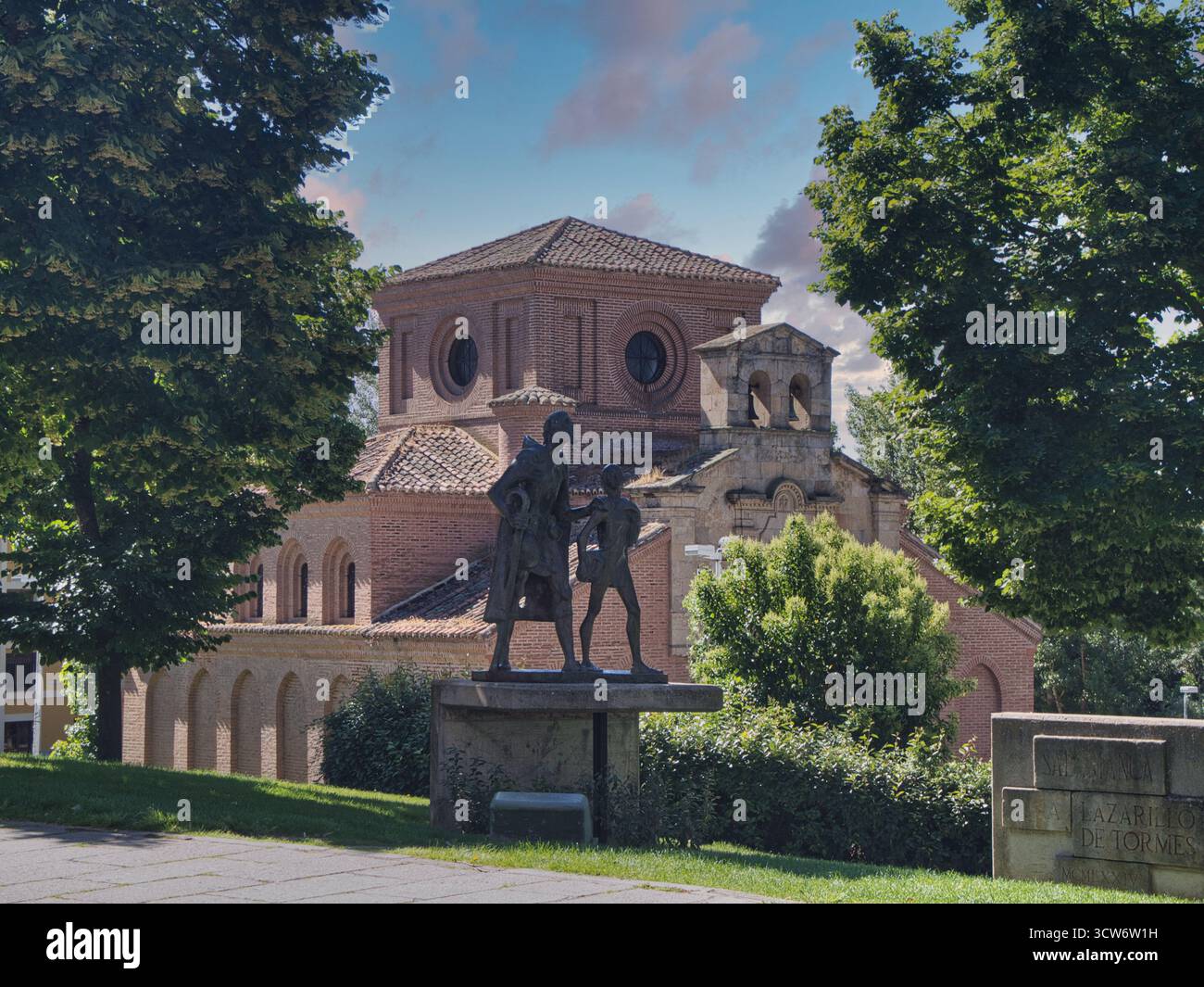 Monumento e Cappella Lazarillo de Tormes - Statua di figure letterarie incorniciate da alberi con mattoni di hermitage sullo sfondo. Foto Stock