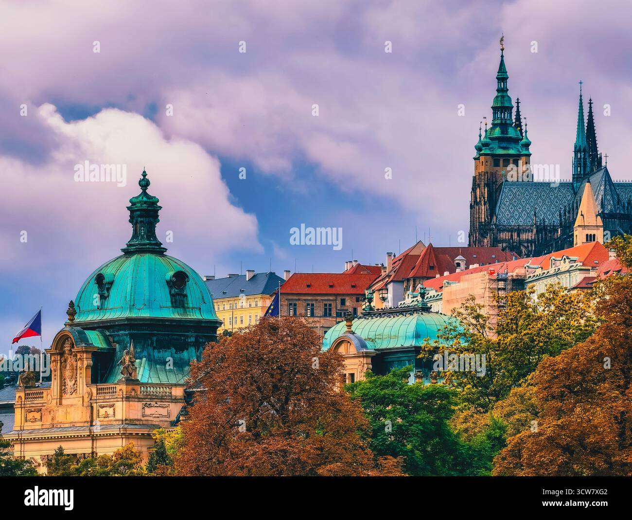Storico paesaggio urbano di Praga con la cattedrale di San Vito, gli alberi d'autunno, la bandiera ceca e la cupola di rame in altissima risoluzione Foto Stock