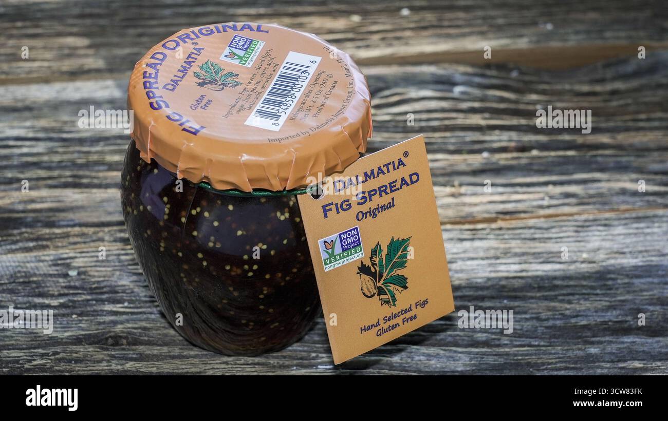 NORWALK, CT, USA- 10 OTTOBRE 2025: Un vaso di vetro di spargimento di fichi si trova su una superficie rustica in legno. Il vaso è dotato di un coperchio marrone e di un'etichetta evidenziata Foto Stock