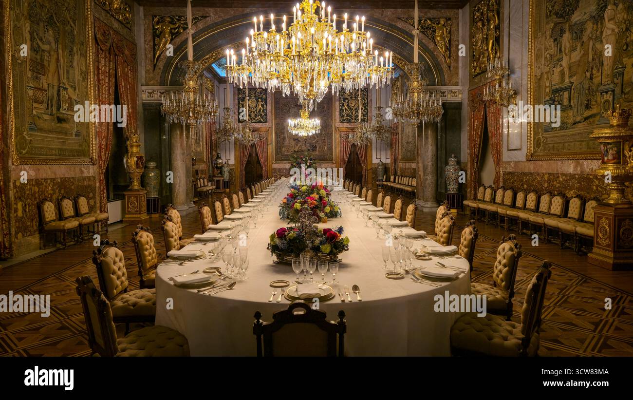 Madrid, Spagna – 30 settembre 2025: Sala per banchetti formale e lampadario presso il Palazzo reale Foto Stock