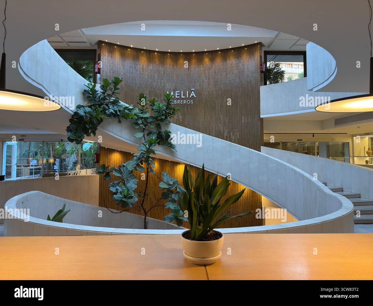 Siviglia, Spagna – 2 ottobre 2025: Scala a chiocciola interna e design della hall dell'hotel Meliá Foto Stock