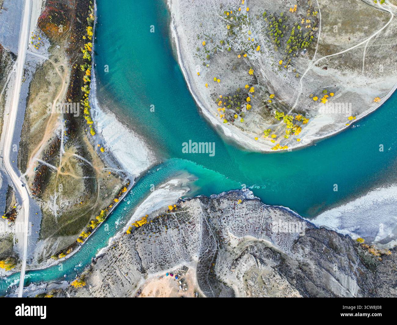 Riprese aeree che catturano le vibranti acque turchesi del fiume Katun mentre incontra un affluente, con sponde rocciose e fogliame autunnale Foto Stock