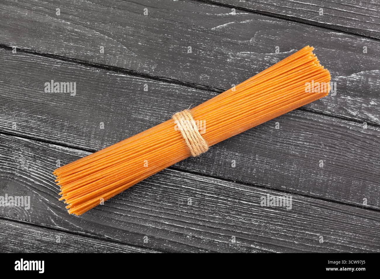 vista dall'alto spaghetti integrali marrone su sfondo in legno nero Foto Stock