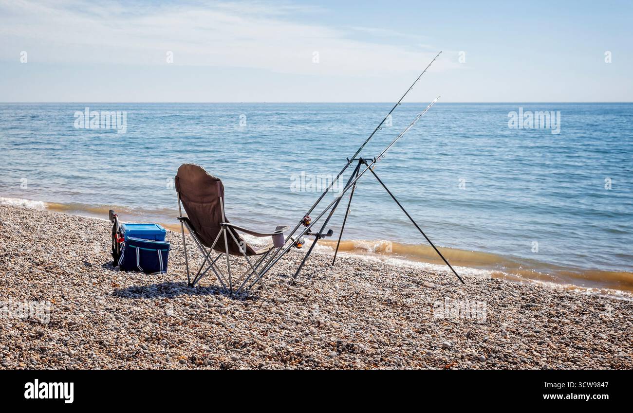 Coppia di canne da pesca allestite sulla spiaggia per la pesca in mare senza persone nel Dorset, Regno Unito Foto Stock