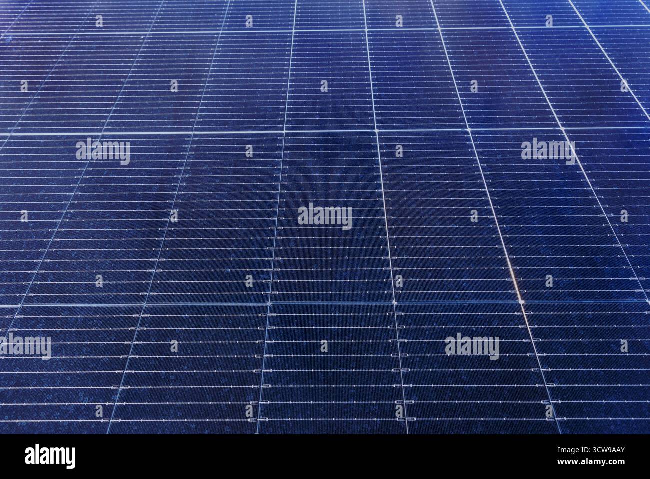 Cornice completa di pannelli solari fotovoltaici con motivo geometrico e superficie riflettente blu scuro Foto Stock