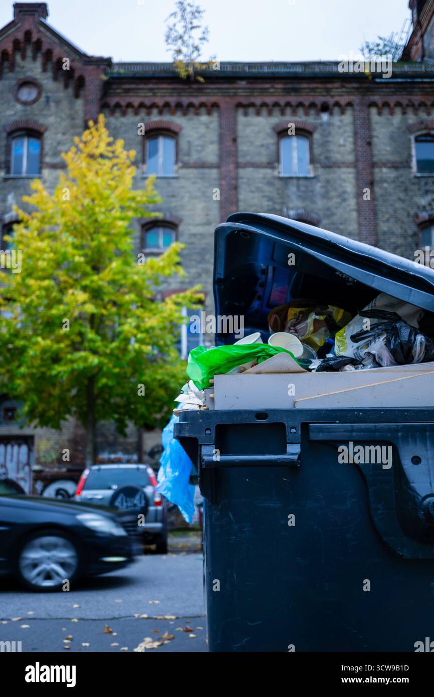 Traboccante di rifiuti di fronte a uno storico edificio abbandonato a Berlino, Germania, che mette in evidenza i rifiuti urbani e il degrado. Foto Stock
