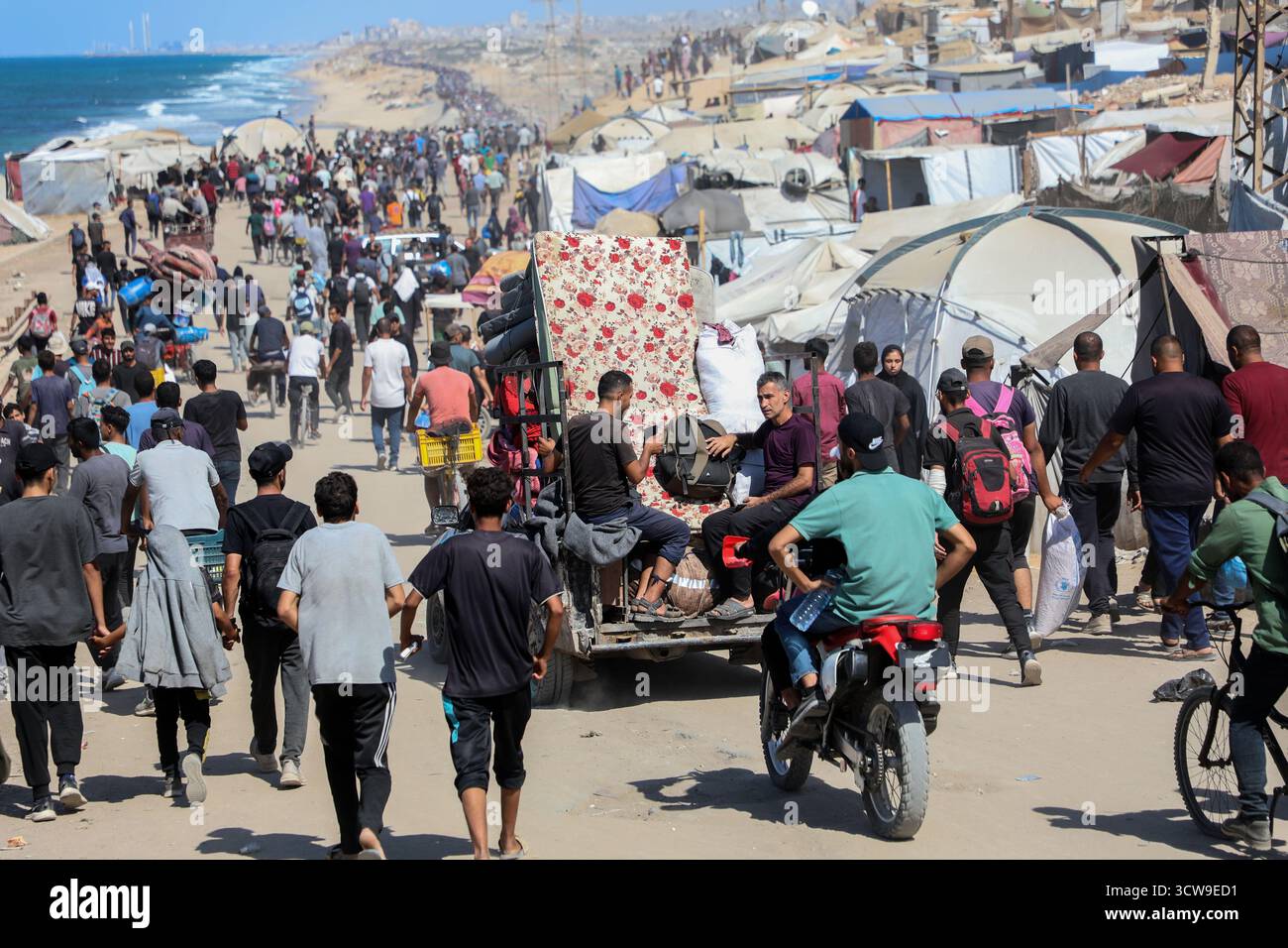 Gaza. 10 ottobre 2025. I palestinesi si spostano su strada vicino alla Striscia centrale di Gaza tornando a Gaza City, 10 ottobre 2025. I palestinesi sfollati hanno iniziato a tornare dalla parte meridionale della Striscia di Gaza a nord dopo che l'esercito israeliano ha annunciato che ai civili è permesso muoversi attraverso la strada costiera di Rashid e la strada di Salah al-DIN, hanno detto fonti locali venerdì. Crediti: Rizek Abdeljawad/Xinhua/Alamy Live News Foto Stock