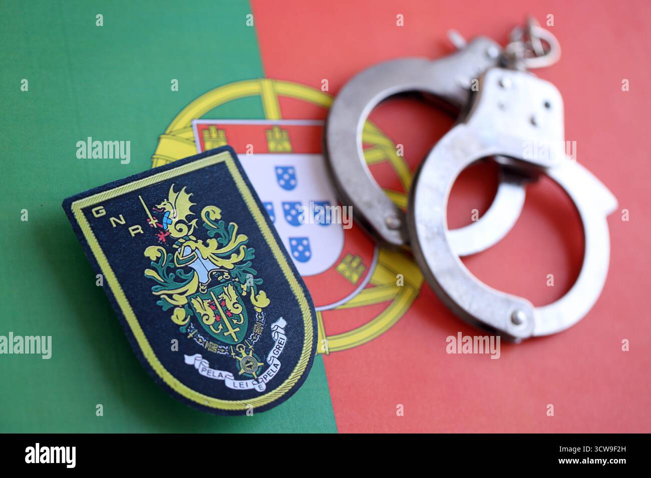 KIEV, UCRAINA - 6 SETTEMBRE 2025 Portogallo Guardia Nazionale Repubblicana patch e manette sulla bandiera nazionale primo piano Foto Stock