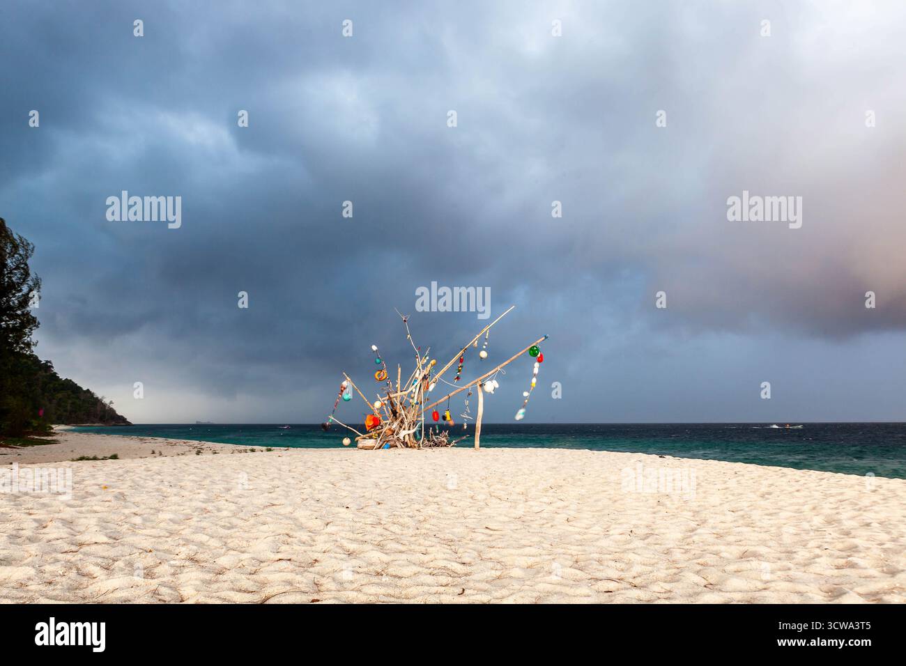 Spettacolari nuvole di tempesta sul Mar delle Andamane color smeraldo e opere d'arte sulla spiaggia di Koh Adang, Thailandia. Uno splendido paesaggio tropicale. Foto Stock