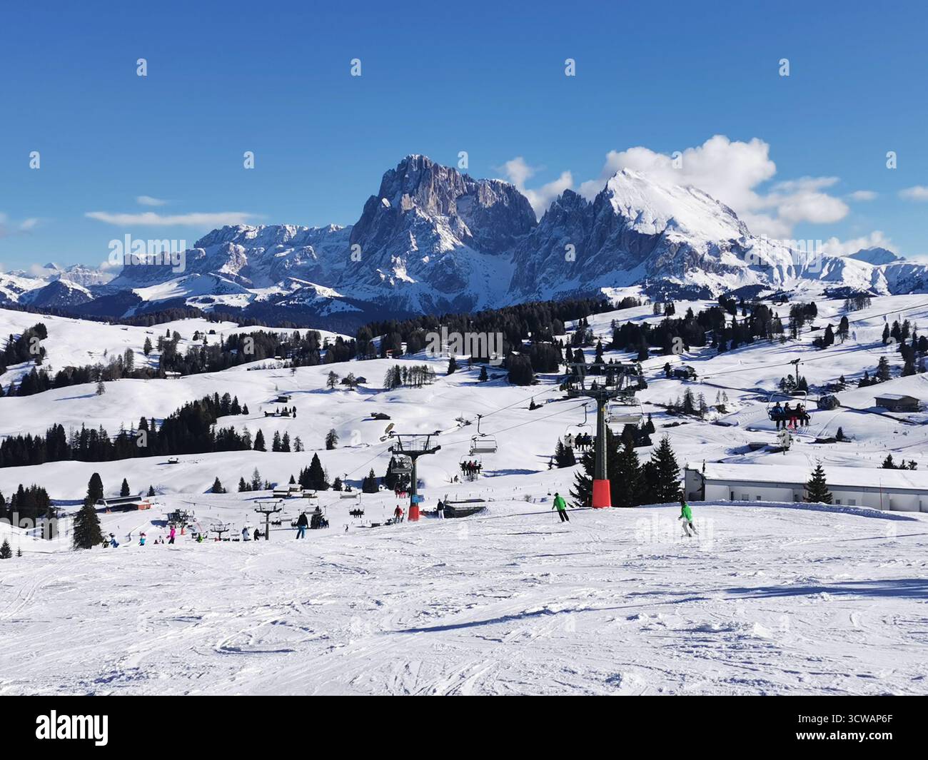 Piste da sci innevate sull'Alpe di Siusi, alto Adige, con l'iconica vetta del Sassolungo (Langkofel) alle spalle: Un dramma dolomitico sulla più grande d'Europa - Immagine stock catturata con smartphone