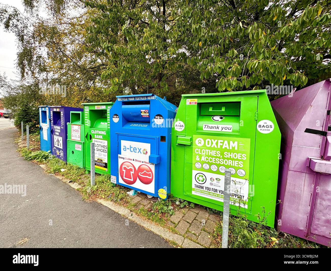 Contenitori Oxfam e della collezione di beneficenza per abbigliamento, scarpe e accessori indesiderati, villaggio di Holcombe Brook a Ramsbottom, Greater Manchester, Regno Unito Foto Stock