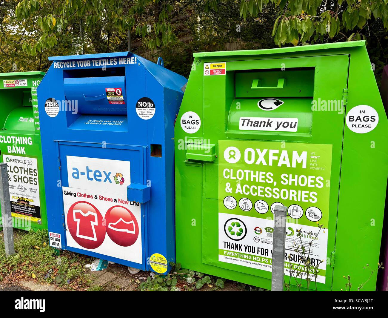 Contenitori Oxfam e della collezione di beneficenza per abbigliamento, scarpe e accessori indesiderati, villaggio di Holcombe Brook a Ramsbottom, Greater Manchester, Regno Unito Foto Stock