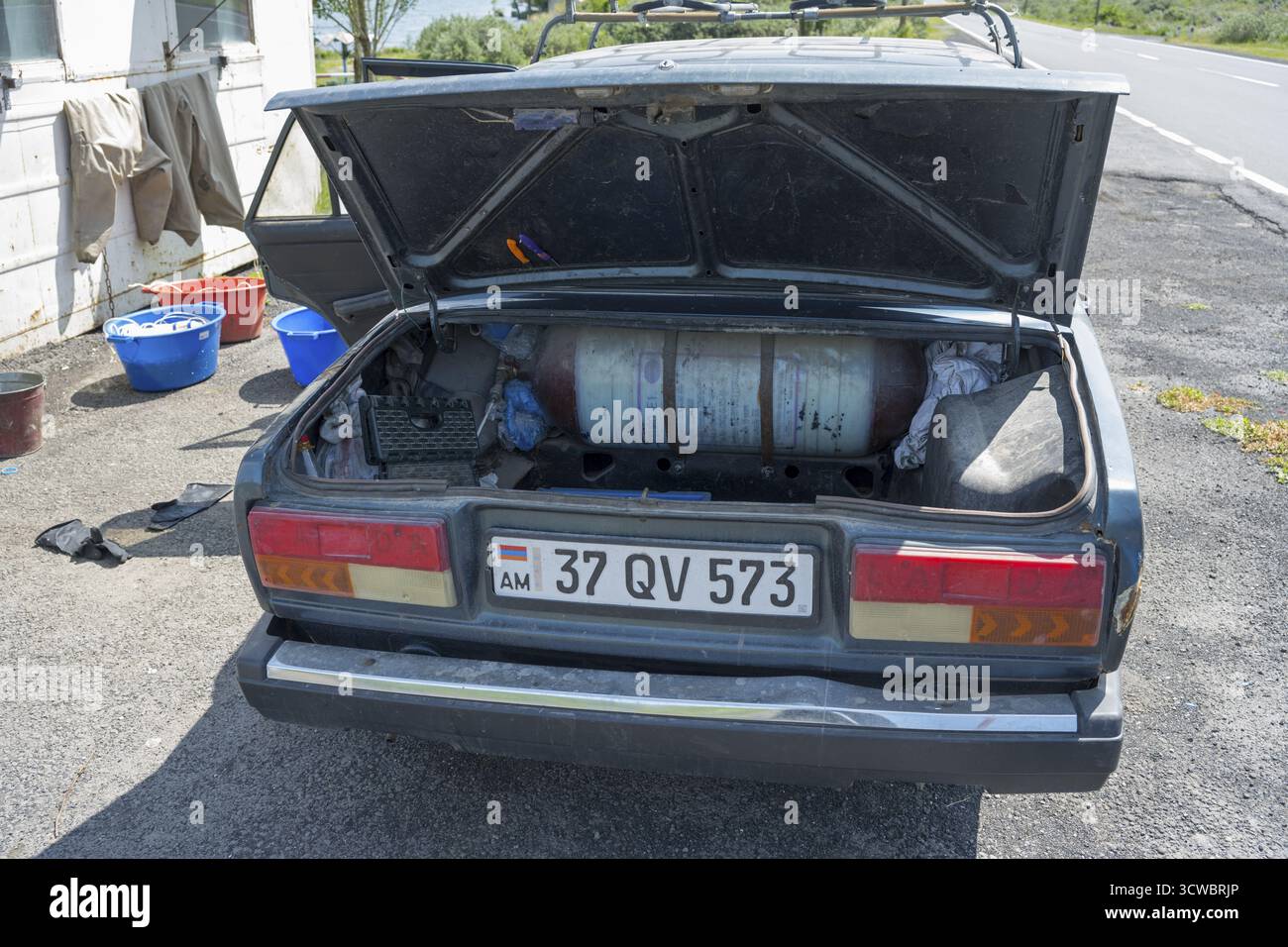 Auto vecchia con stivali aperti, bomboletta di gas e attrezzi nelle giornate di sole accanto alla strada, l'auto è dotata di un serbatoio di gas aggiornato per poter guidare a costi più bassi, Armenia Foto Stock