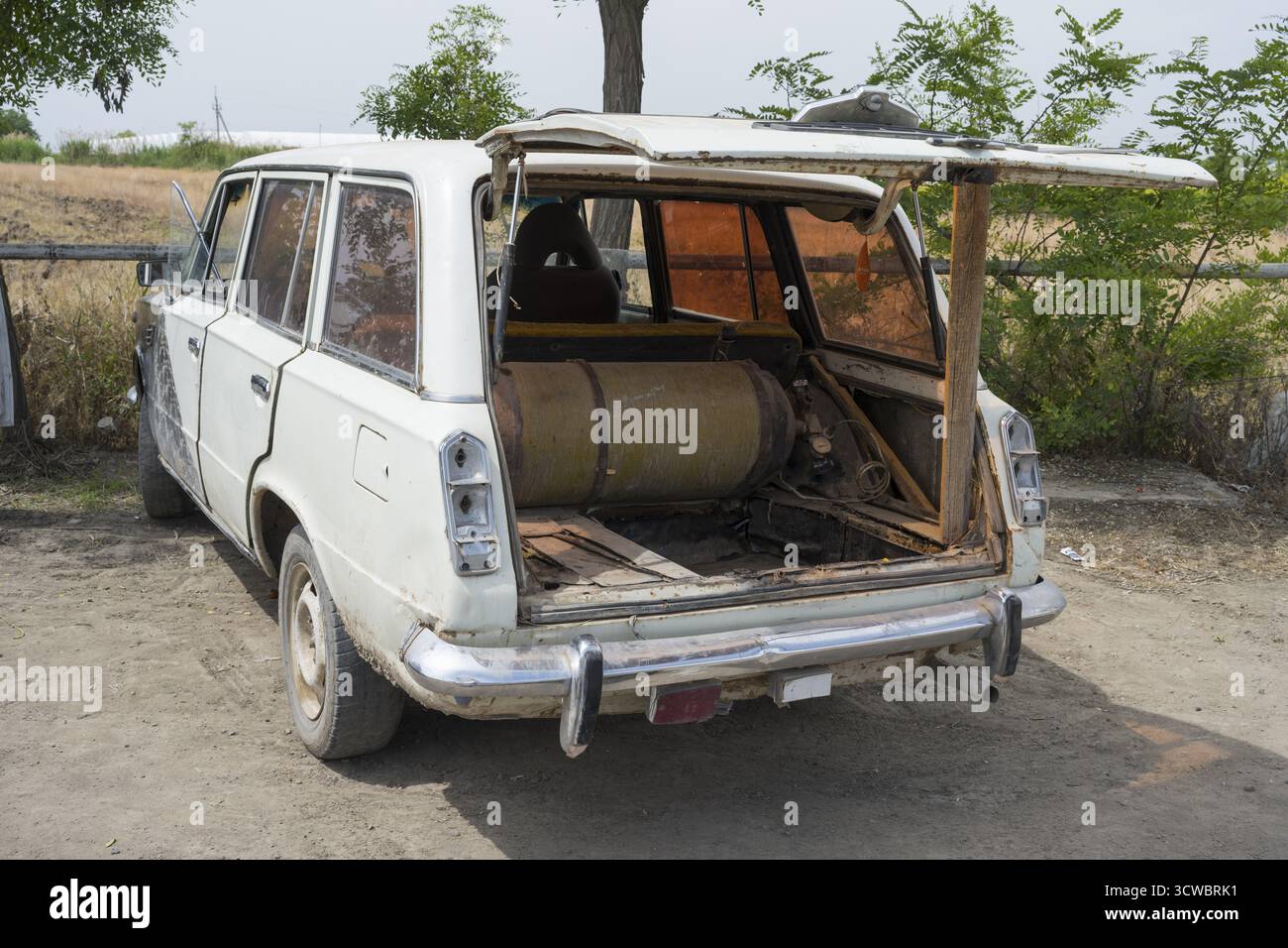 Una vecchia station wagon con un portellone aperto mostra una bottiglia di gas all'interno, l'auto ha un serbatoio di gas aggiornato per poter guidare a costi più bassi, l'Armenia Foto Stock