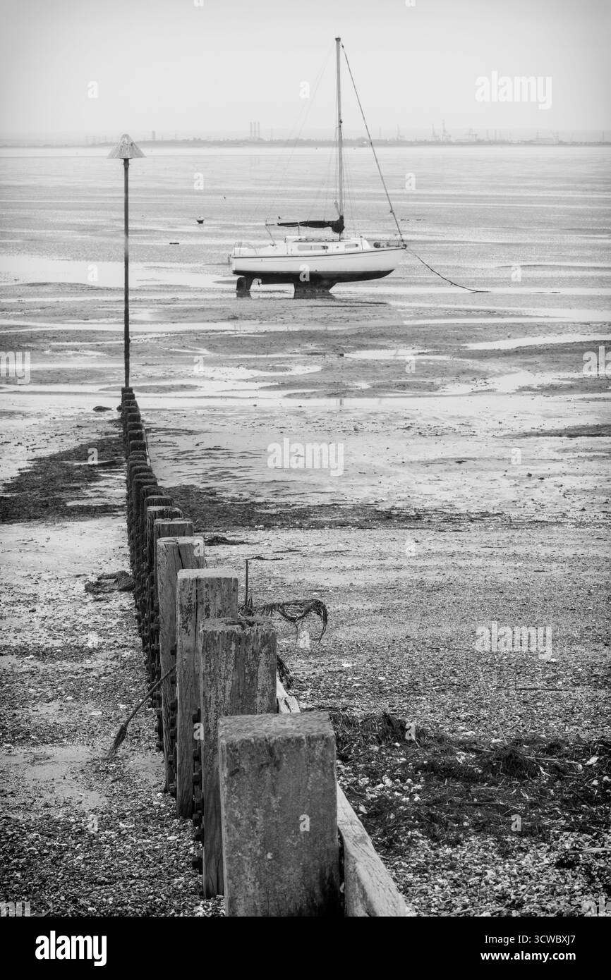 Yacht e Groyne a Low Tide sull'estuario del Tamigi in una mattinata di ottobre molto noiosa Foto Stock