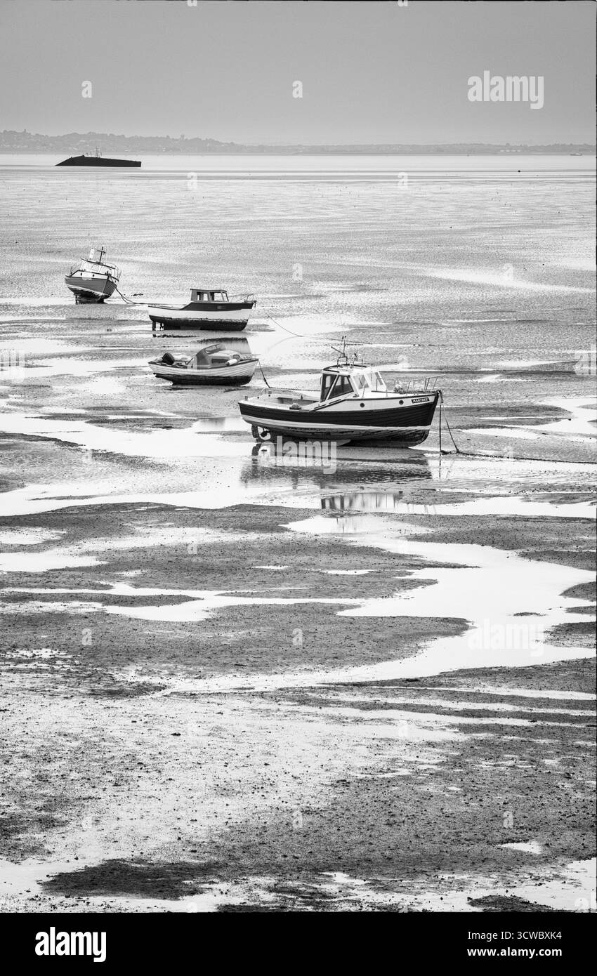 Barche a riposo su distese fangose al largo di Thorpe Bay in una mattinata di ottobre molto noiosa Foto Stock