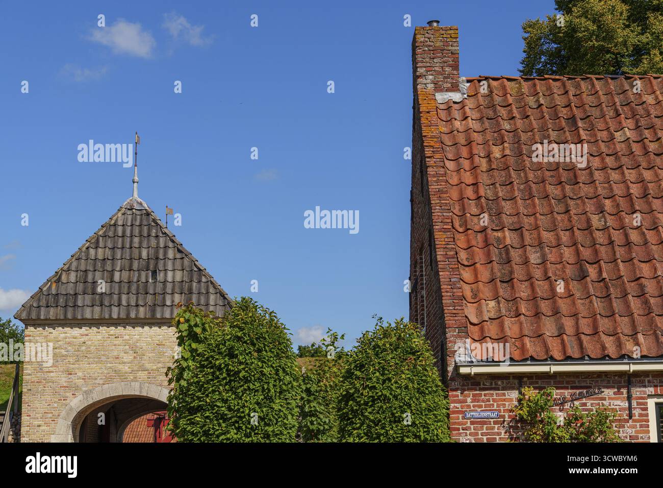 Parte di una casa in mattoni con un caratteristico tetto, circondata da piante e un cielo limpido, Bourtange, Paesi Bassi Foto Stock Parte di una casa in mattoni con un caratteristico tetto, circondata da piante e un cielo limpido, Bourtange, Paesi Bassi Foto Stock