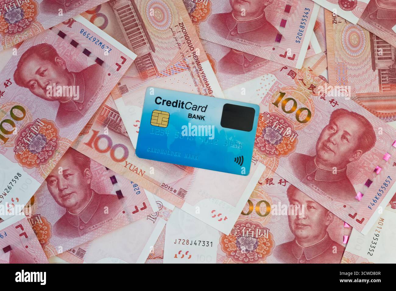 Primo piano con carta di credito e contanti cinesi yuan. una carta di plastica blu su uno sfondo di soldi. Foto Stock