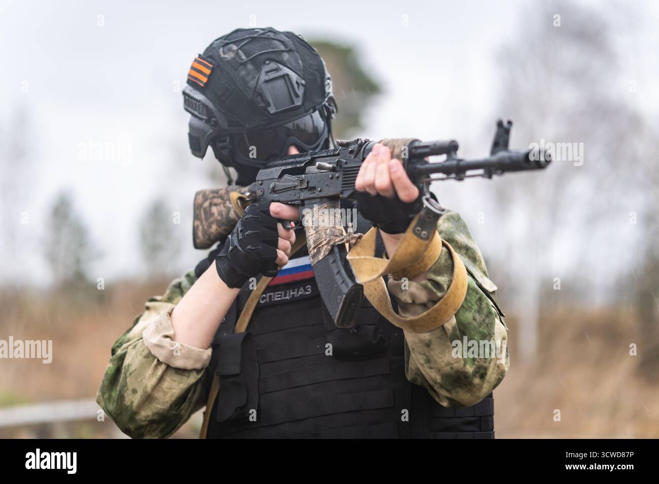Soldati russi delle forze armate d'assalto in azione di combattimento. Un soldato delle forze speciali russe tiene in mano il fucile d'assalto Kalashnikov e si mette in piedi Foto Stock