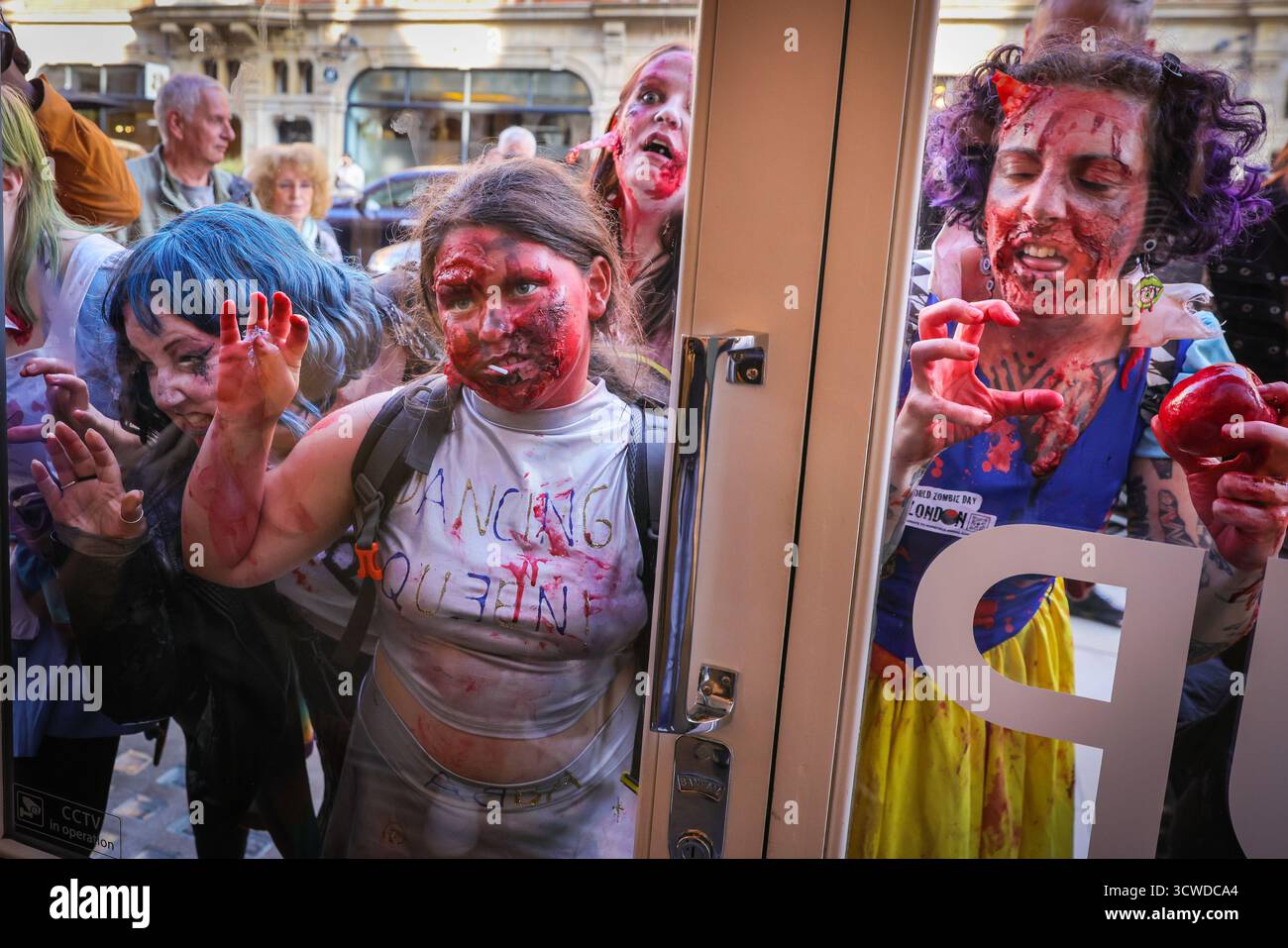 Londra, Regno Unito. 11 ottobre 2025. I fotografi all'interno di un negozio di fotocamere Leica sono ansiosi di immortalare l'apocalisse zombie che passa. I partecipanti celebrano l'annuale giornata Mondiale dello Zombie con una passeggiata nel centro di Londra. L'evento è non politico e adatto alle famiglie, con molti fan che si vestono con abiti spaventosi e costumi creativi dell'apocalisse. Crediti: Imageplotter/Alamy Live News Foto Stock