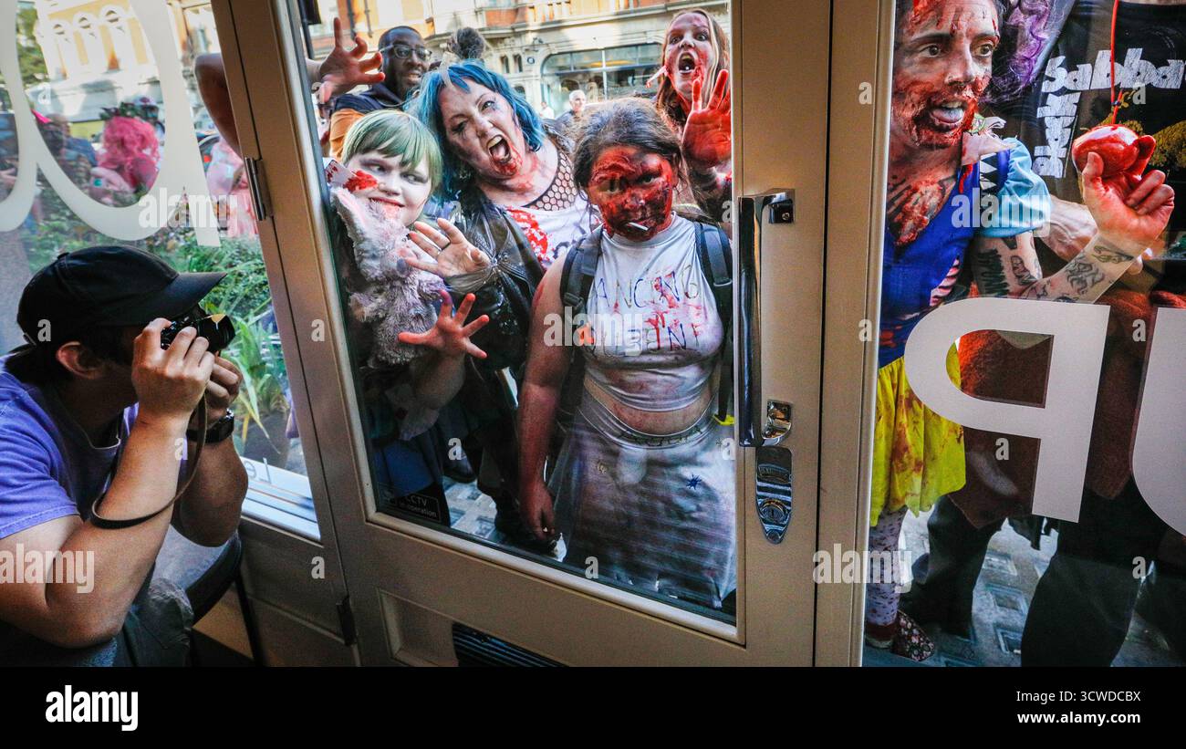 Londra, Regno Unito. 11 ottobre 2025. I fotografi all'interno di un negozio di fotocamere Leica sono ansiosi di immortalare l'apocalisse zombie che passa. I partecipanti celebrano l'annuale giornata Mondiale dello Zombie con una passeggiata nel centro di Londra. L'evento è non politico e adatto alle famiglie, con molti fan che si vestono con abiti spaventosi e costumi creativi dell'apocalisse. Crediti: Imageplotter/Alamy Live News Foto Stock