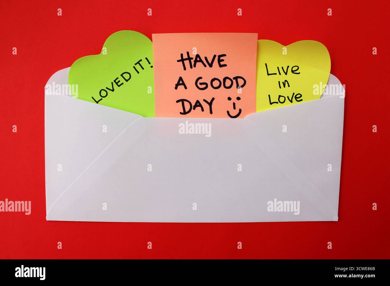 Busta bianca per inviare frasi positive su note adesive colorate Foto Stock