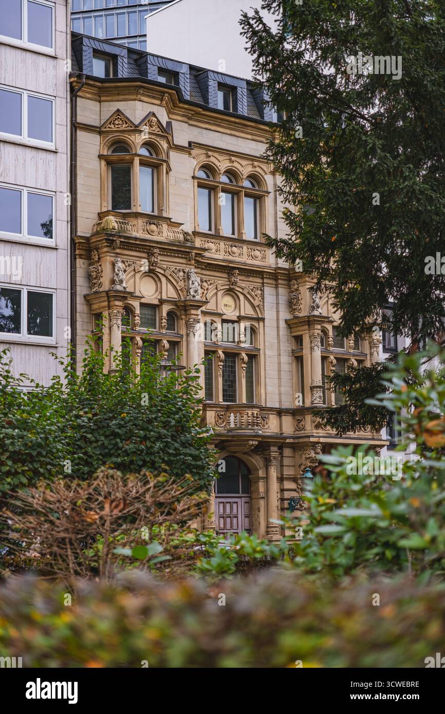 Un edificio storico e ornato a Düsseldorf si erge tra strutture moderne e presenta intricati dettagli architettonici Foto Stock