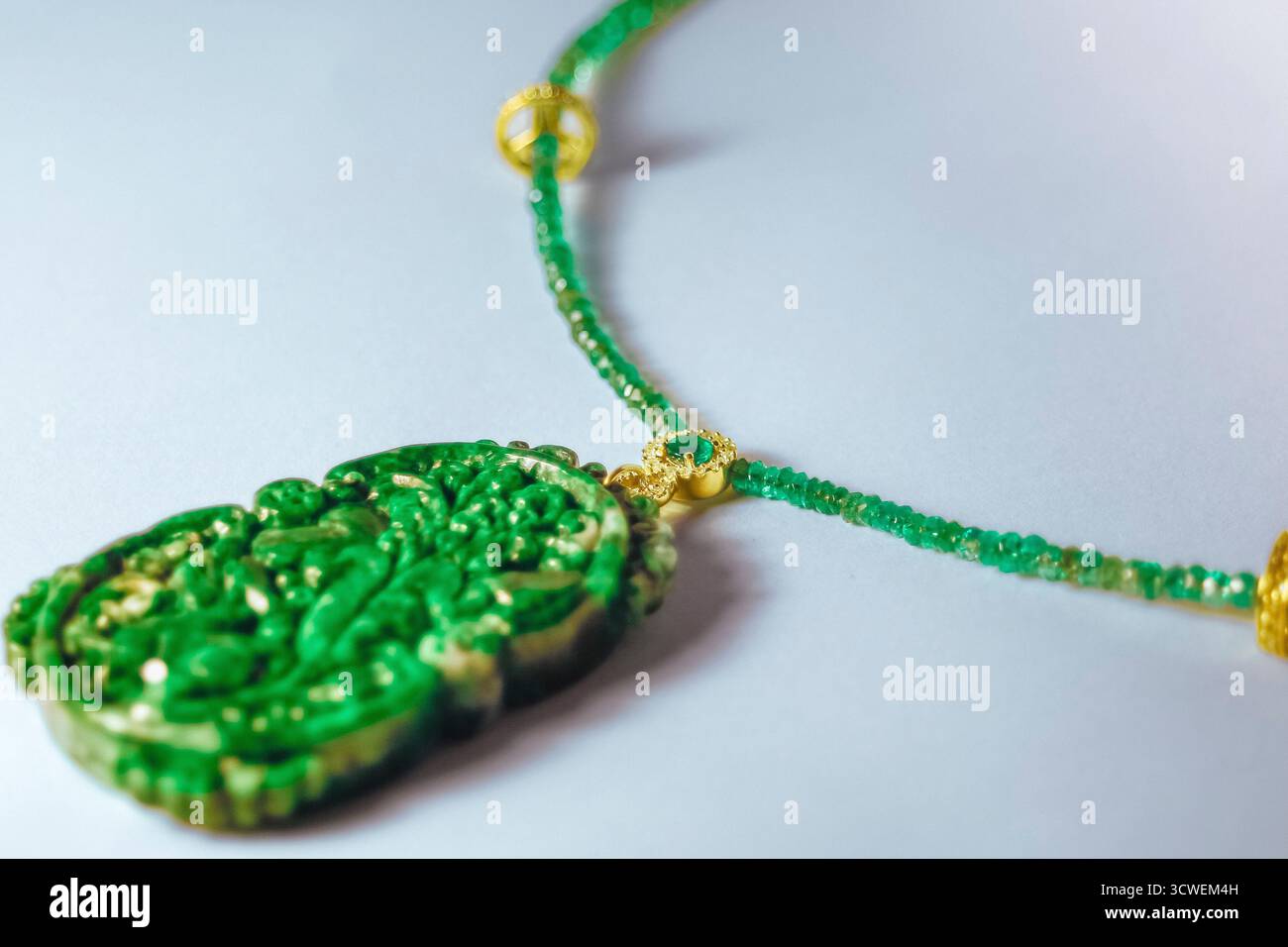 Collana con pendente in giada verde con catena in perline e gioielli con chiusura in oro Foto Stock