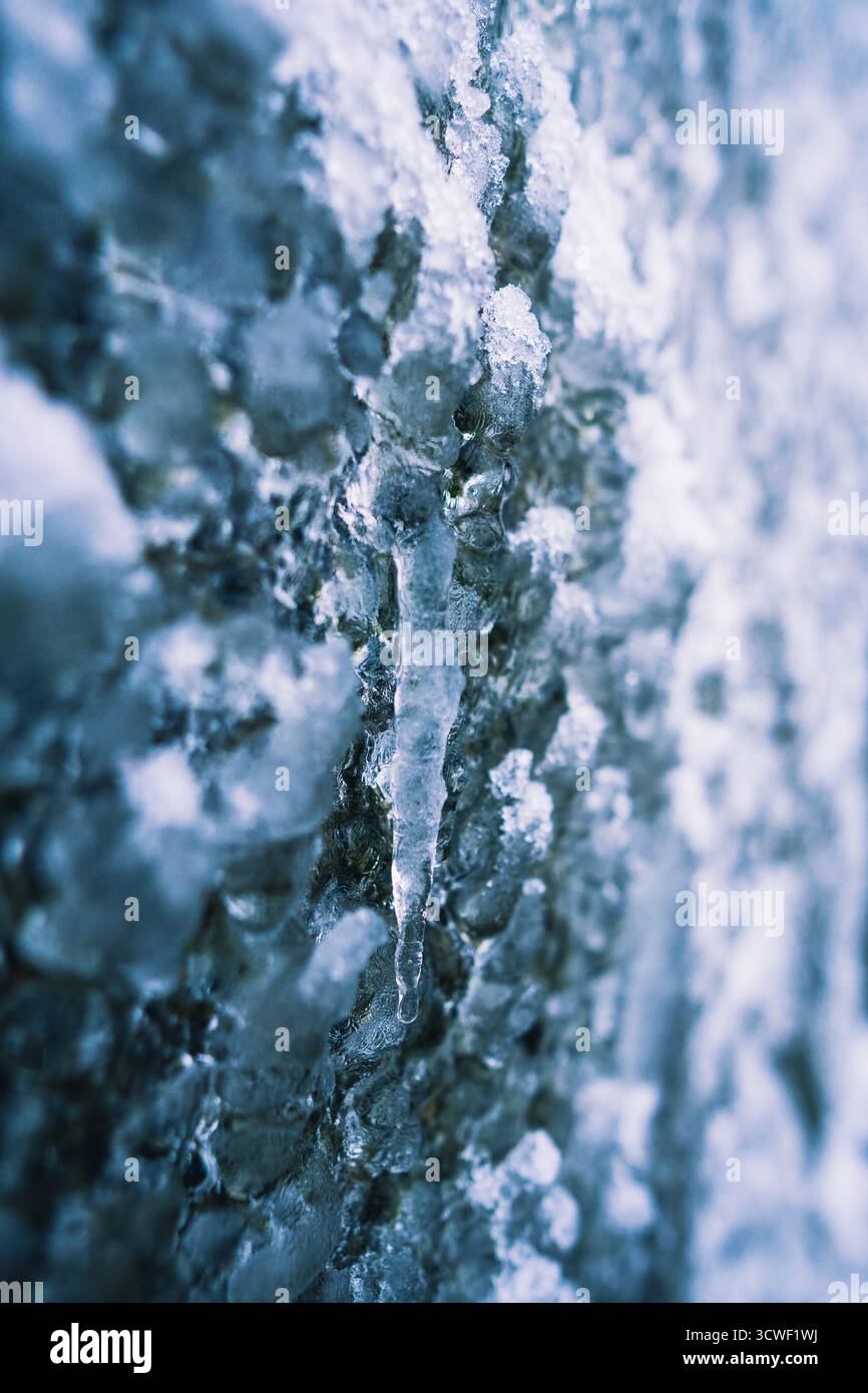 Vista ravvicinata del ghiaccio e dei ghiacciai che si formano su una superficie ghiacciata, che mostra la bellezza delle texture e dei colori invernali. Foto Stock