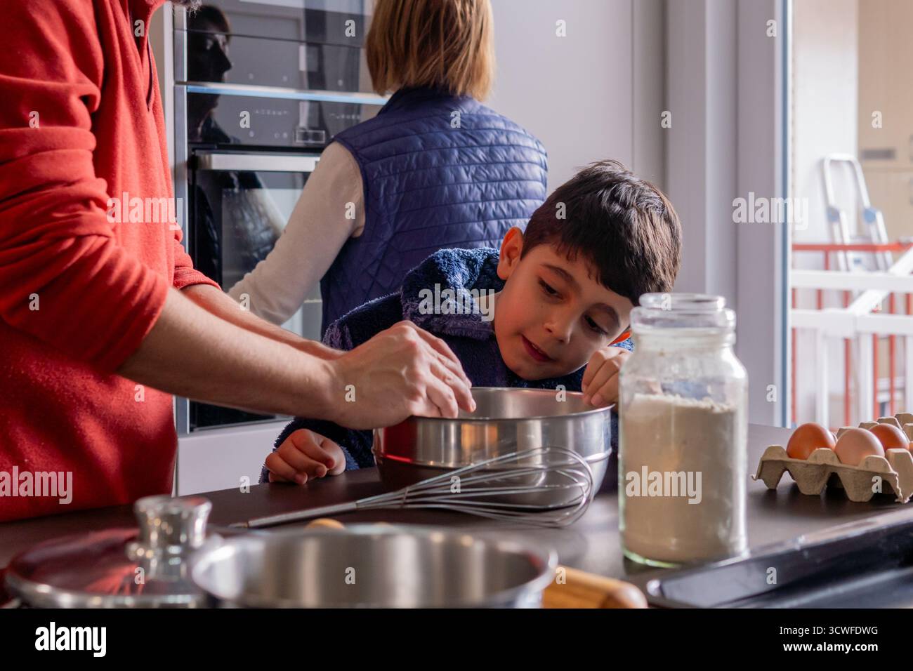 Un ragazzo di generazione alfa che prepara biscotti di natale con la sua famiglia a casa Foto Stock