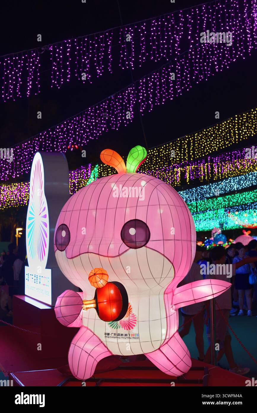 Lerongrong, mascotte ufficiale dei 15 Giochi nazionali della Repubblica Popolare Cinese, tiene una mazza da ping-pong illuminata nel Victoria Park di Hong Kong Foto Stock