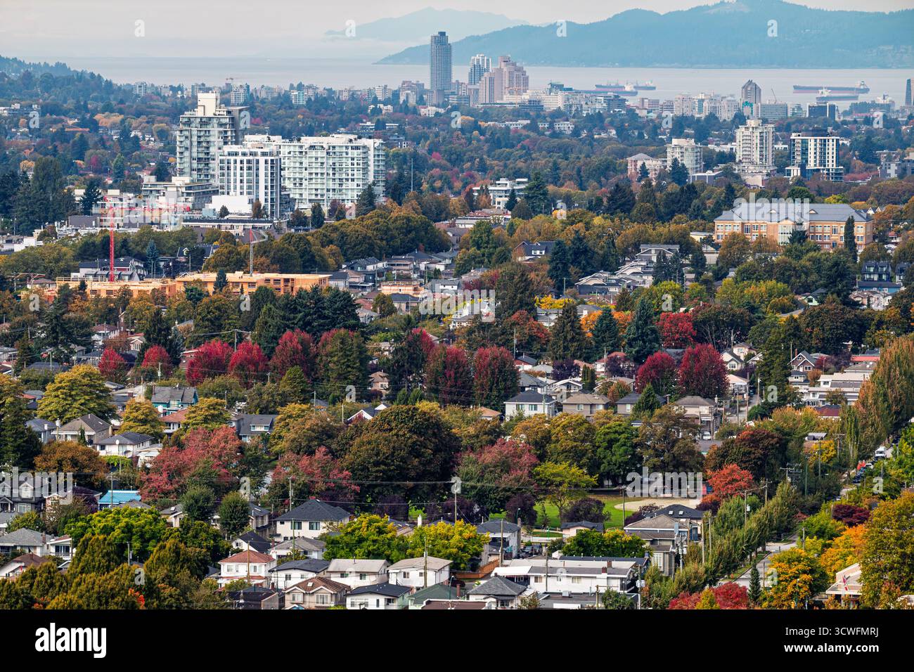 A Vancouver in autunno, le strade si animano con tonalità vivaci. Alberi vestiti di rosso e oro circondano case accoglienti, creando una scena pittoresca Foto Stock