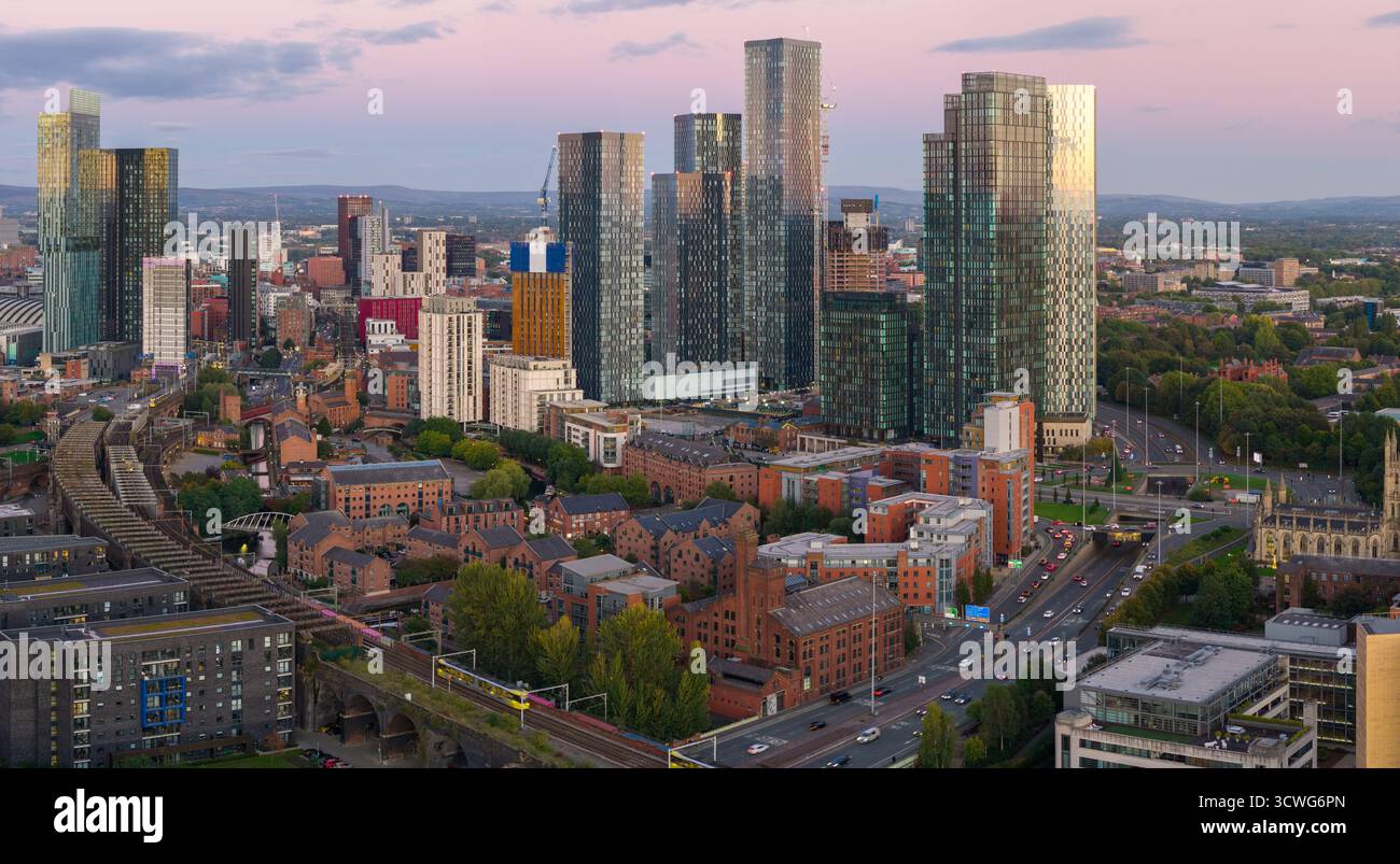 Panorama aereo dello skyline di Manchester al crepuscolo con il viadotto Castlefield e i toni pastello del cielo. Foto Stock