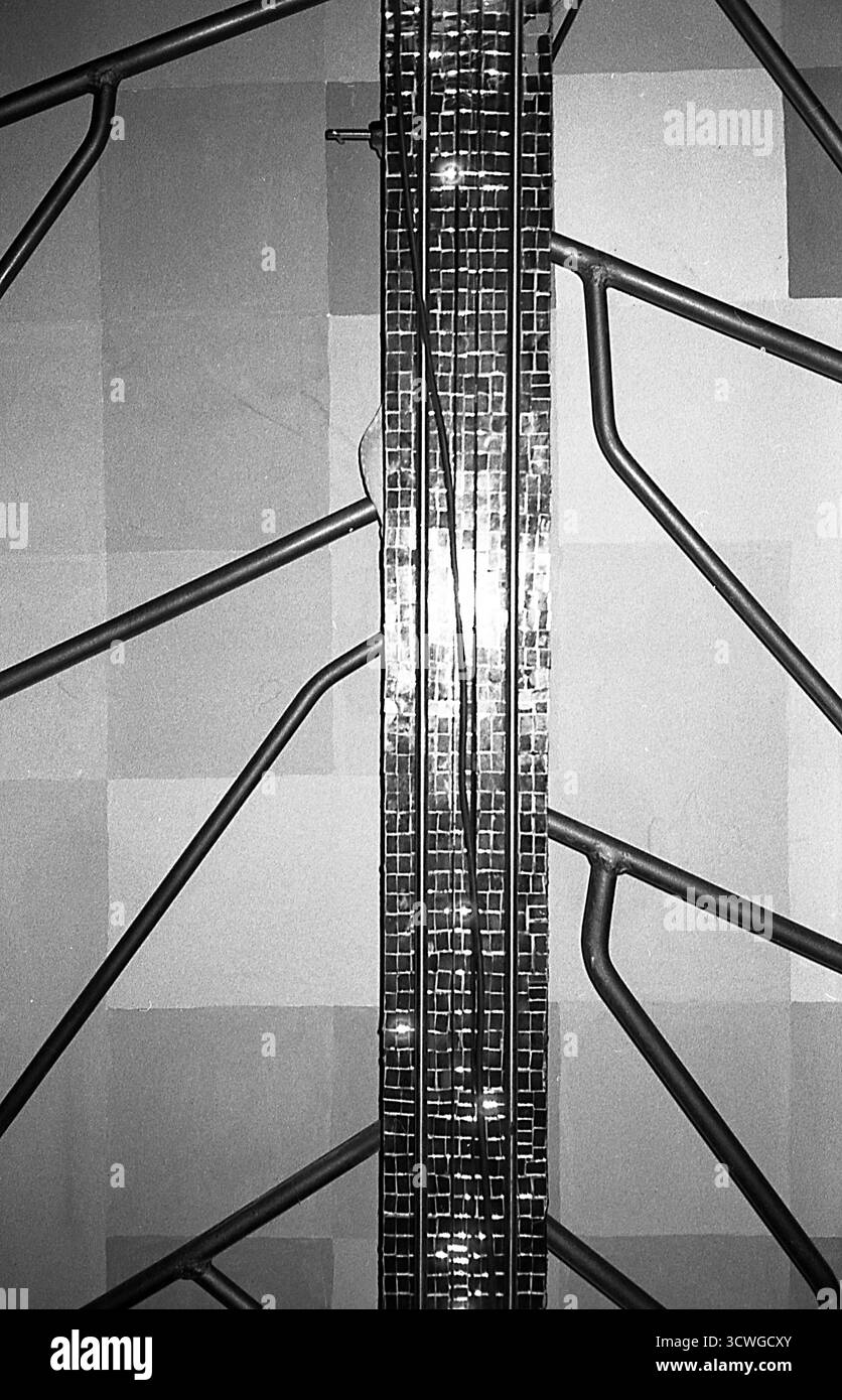 Radiatore a forma di albero accanto a un'installazione artistica con specchi, fotografato con flash diretto su pellicola analogica, creando una scena interna surreale. Foto Stock