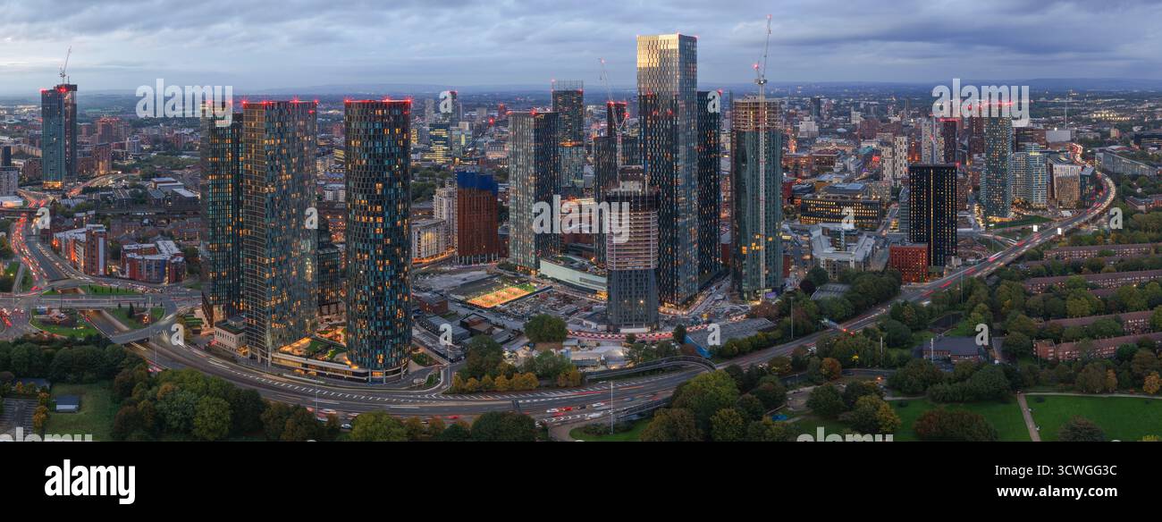 Ampia vista aerea panoramica dello skyline di Manchester e del traffico di Mancunian Way al crepuscolo da Hulme Park. Foto Stock