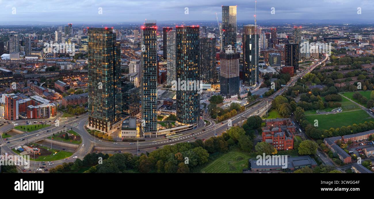 Ampia vista aerea panoramica dello skyline di Manchester e del traffico di Mancunian Way al crepuscolo da Hulme Park. Foto Stock