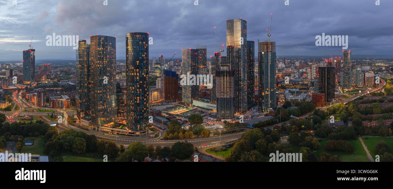 Ampia vista aerea panoramica dello skyline di Manchester e del traffico di Mancunian Way al crepuscolo da Hulme Park. Foto Stock